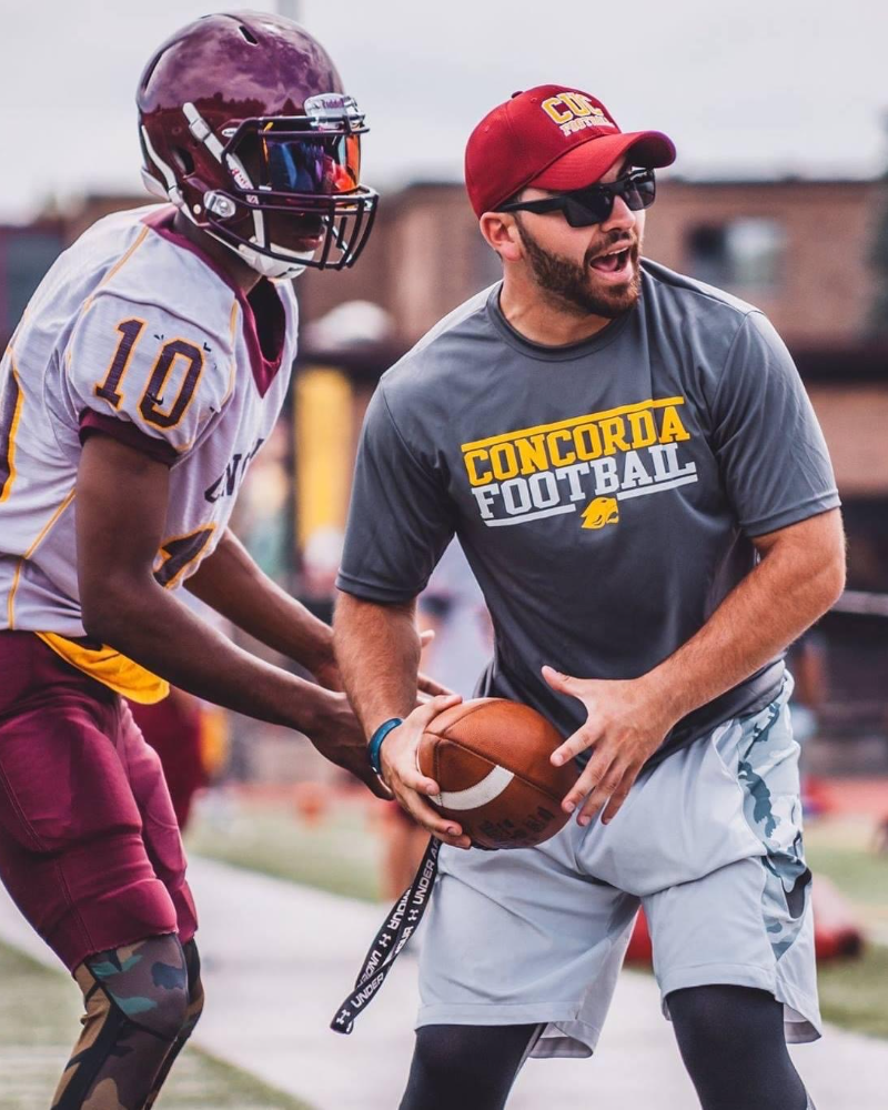 Coach Michael Peters working with a quarterback at Concordia University Chicago